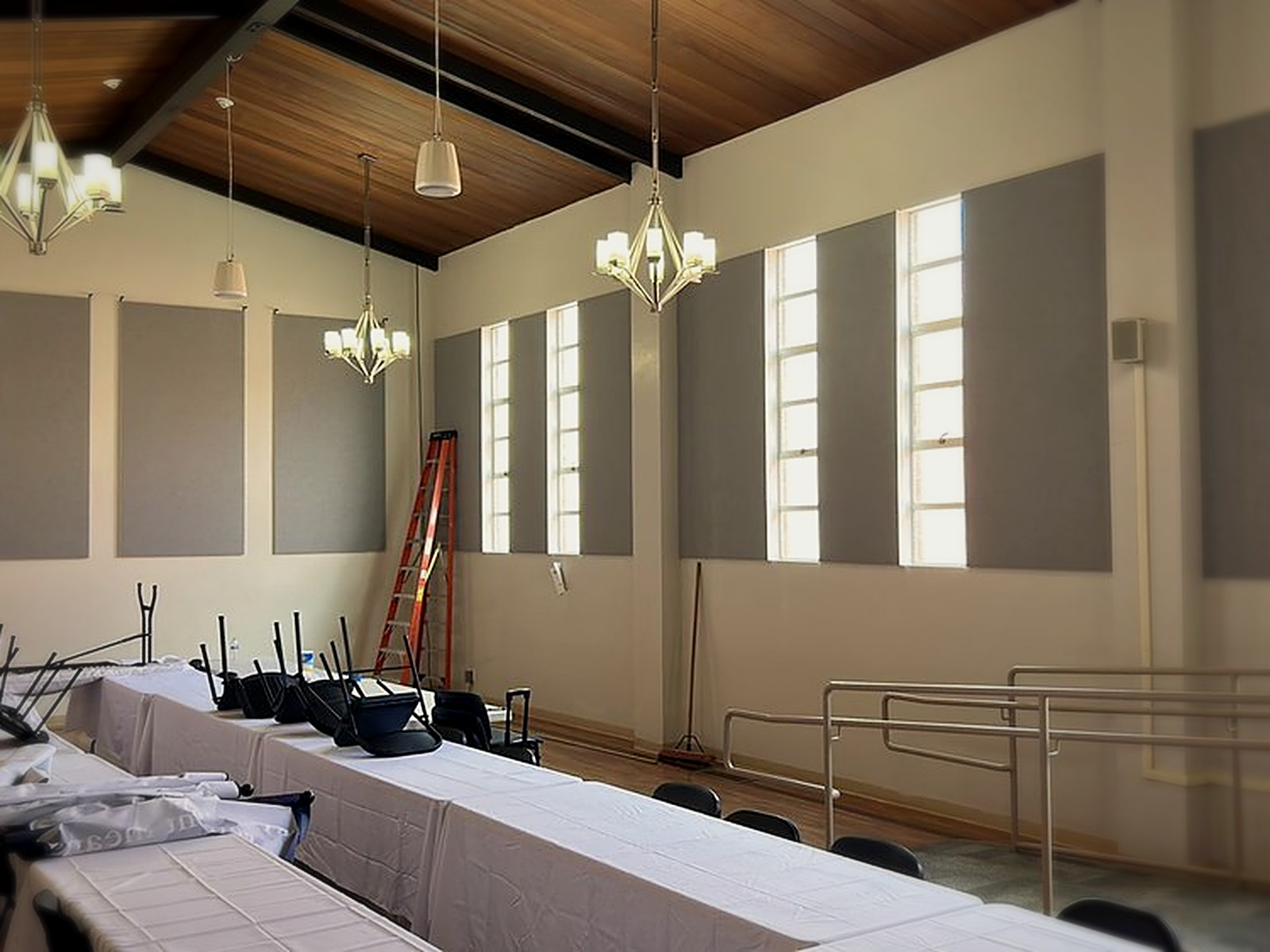 Institutional conference room in Oakland with large grey custom fabric track acoustic panels installed between tall windows