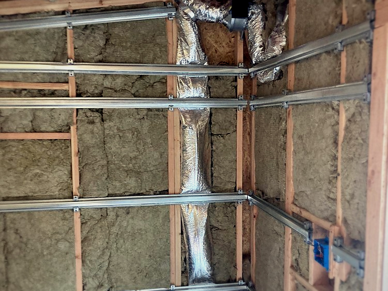 Rockwool insulation with sound isolation clips and hat channel installed across the studio shed walls and ceiling