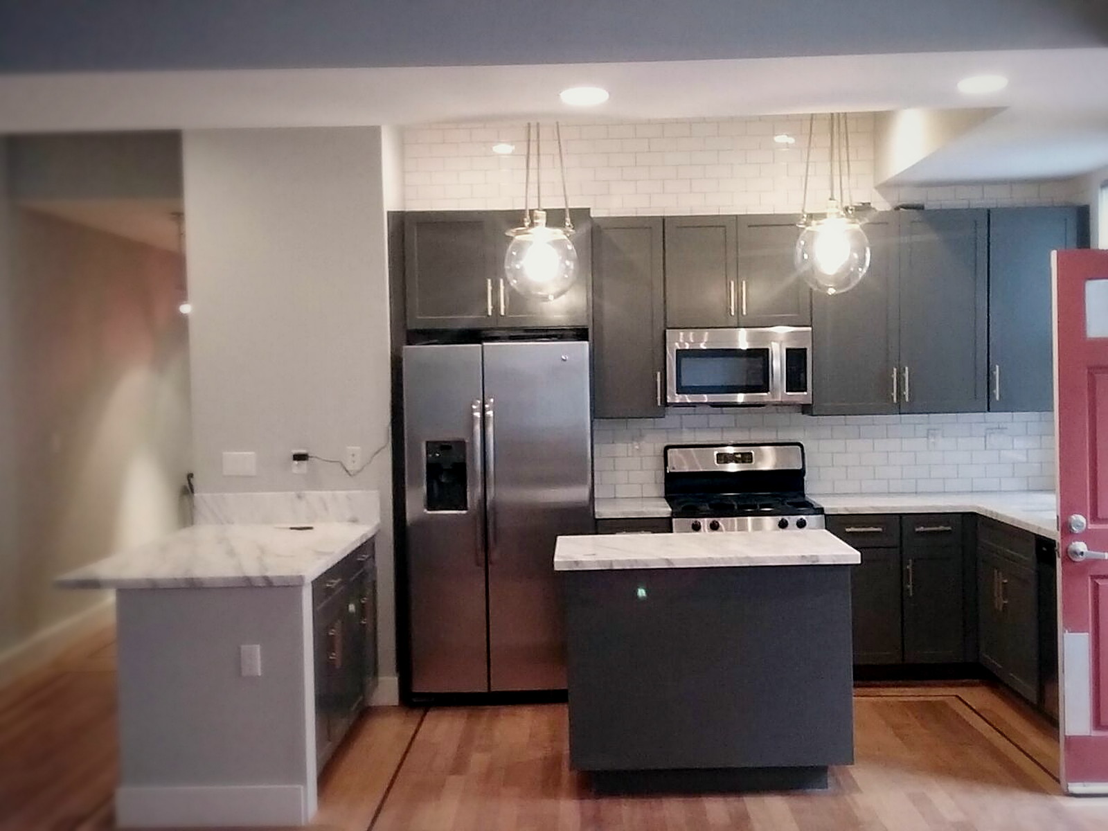 Finished Melrose kitchen with grey cabinets, pendant lighting and a soundproofed ceiling after renovation