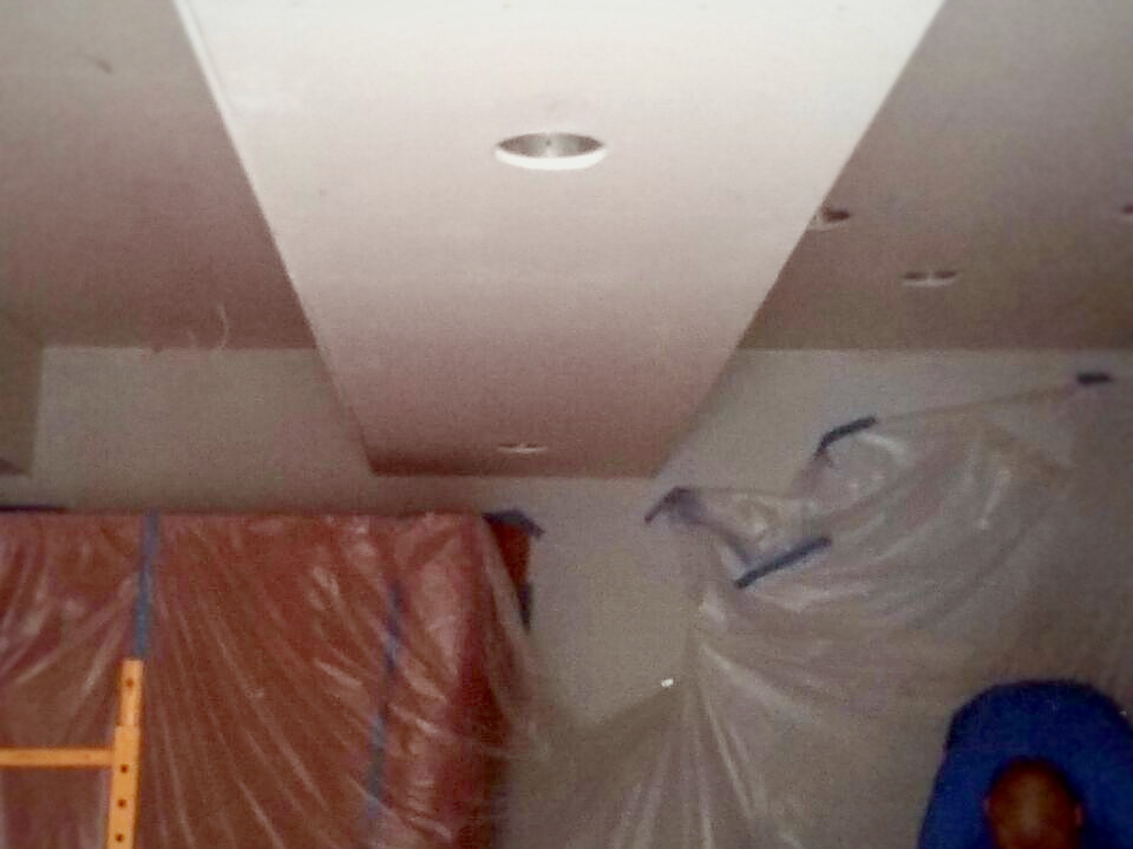 Taped and primed soundproofed ceiling with recessed fixture cans set flush before final paint
