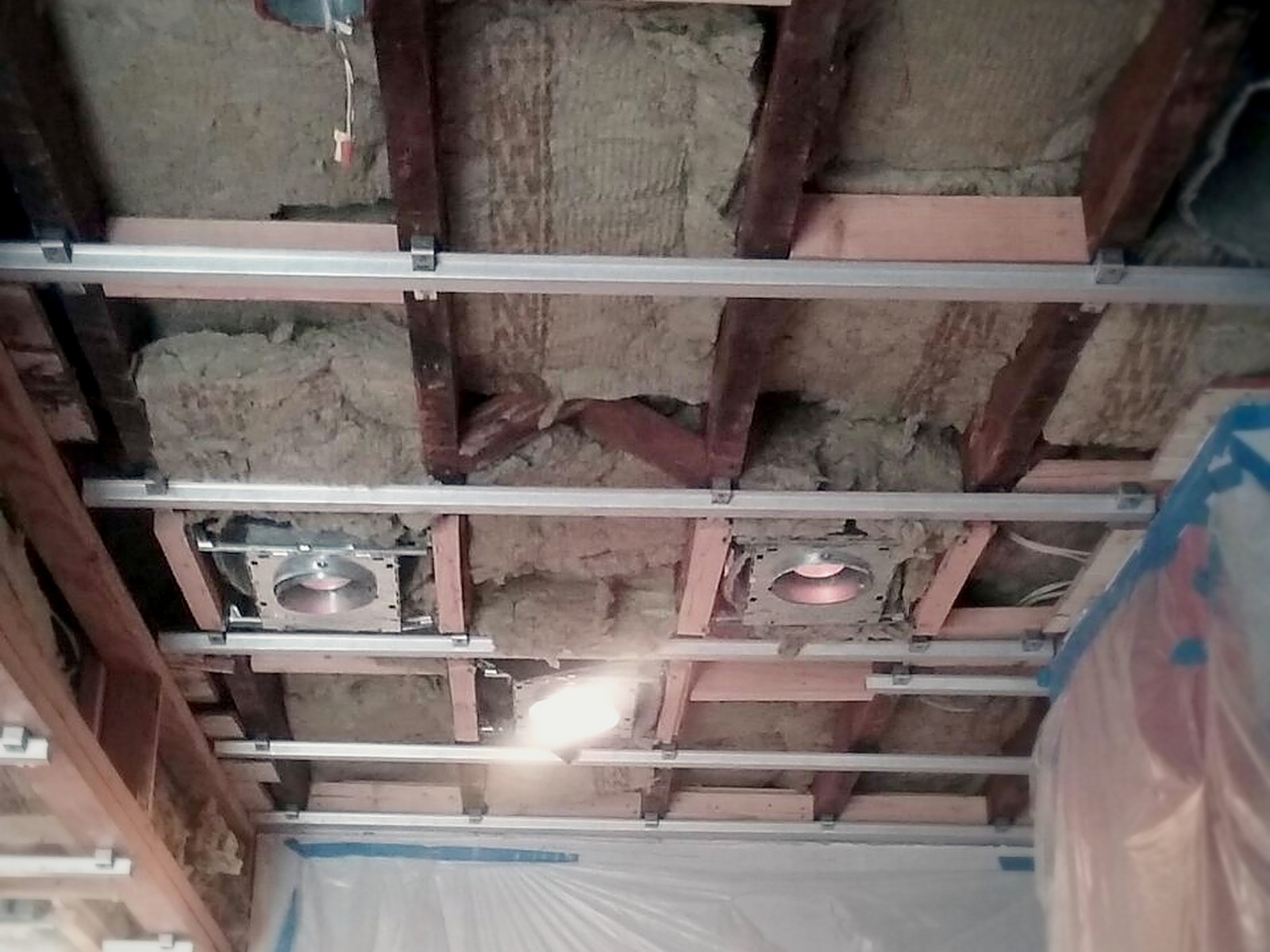 Isolation clips and hat channel installed over mineral wool insulated ceiling joists in a Melrose kitchen