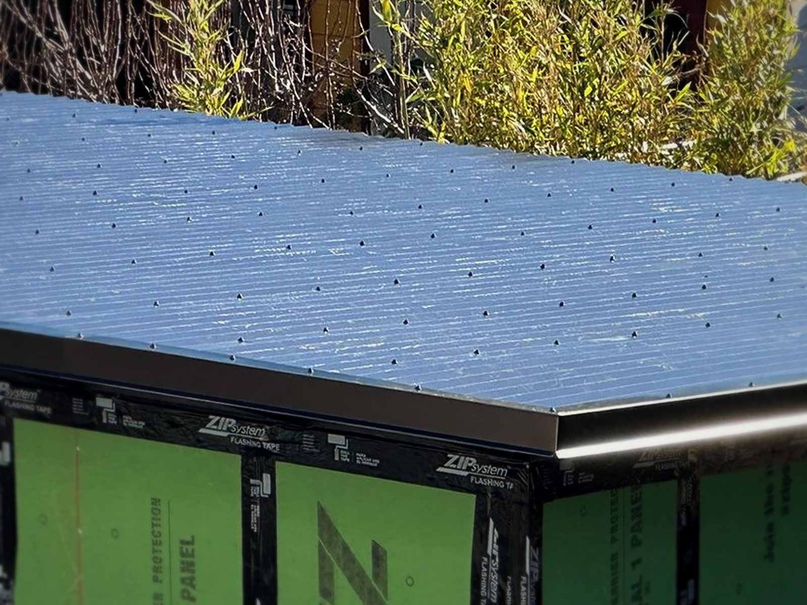 Weather membrane roof deck of the soundproof backyard studio shed fastened over ZIP System sheathed walls