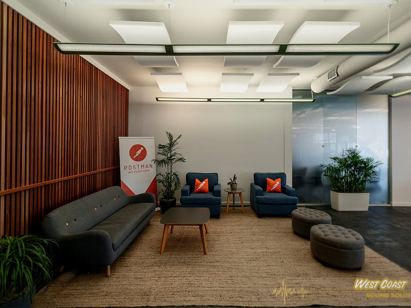 Berkeley office lounge with sculpted white acoustic ceiling clouds above a seating area and slatted wood wall