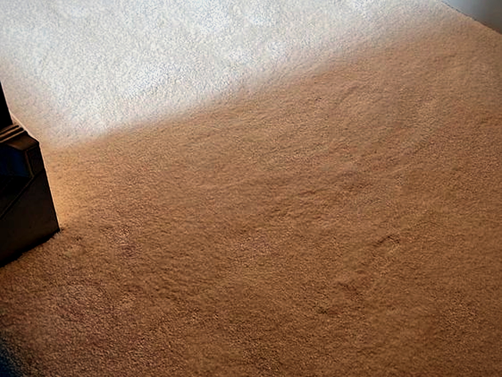 Acoustic underlay laid out across an upstairs hallway before plush carpet is stretched over it