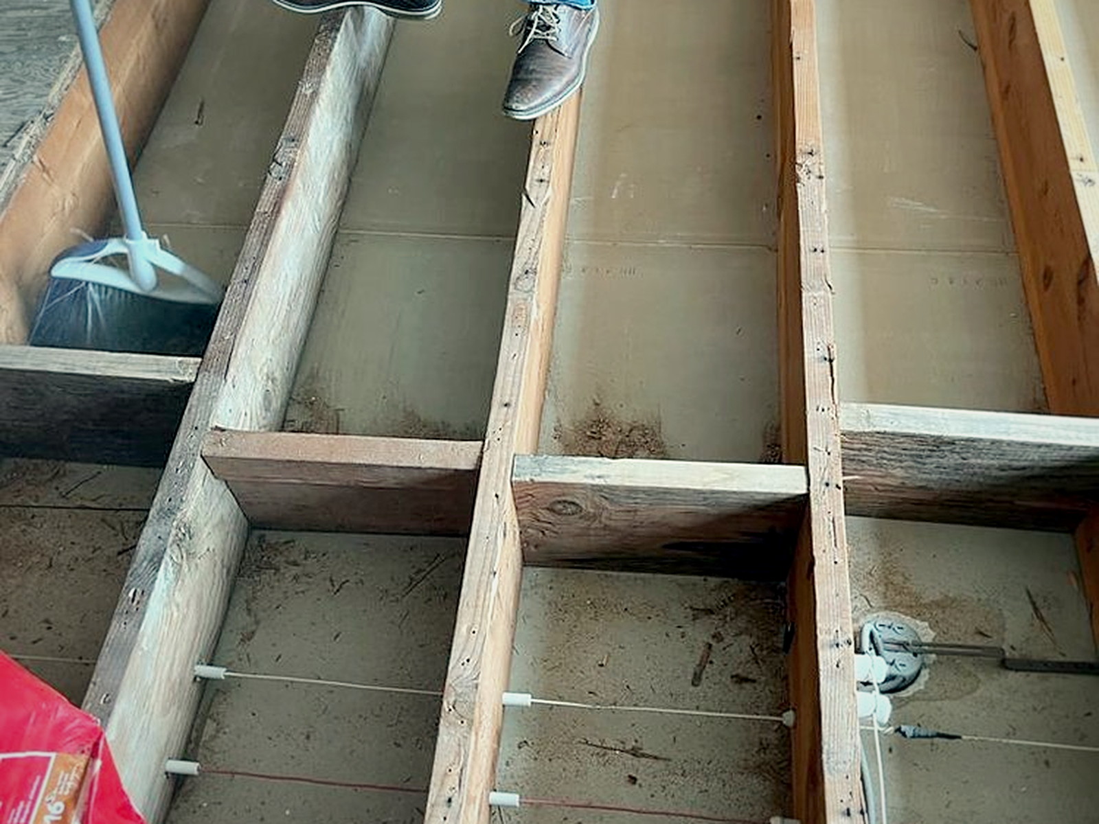 Original subfloor removed to expose floor joists and dated electrical runs in a San Francisco home