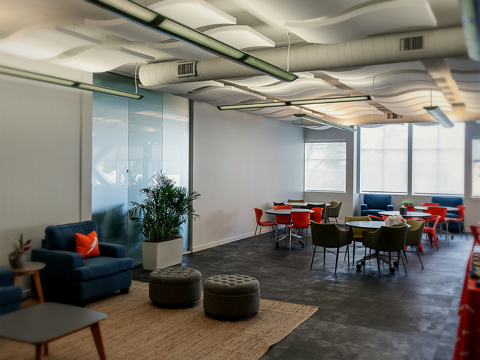 Berkeley office cafe and lounge with sculpted white acoustic clouds covering the ceiling above tables and soft seating