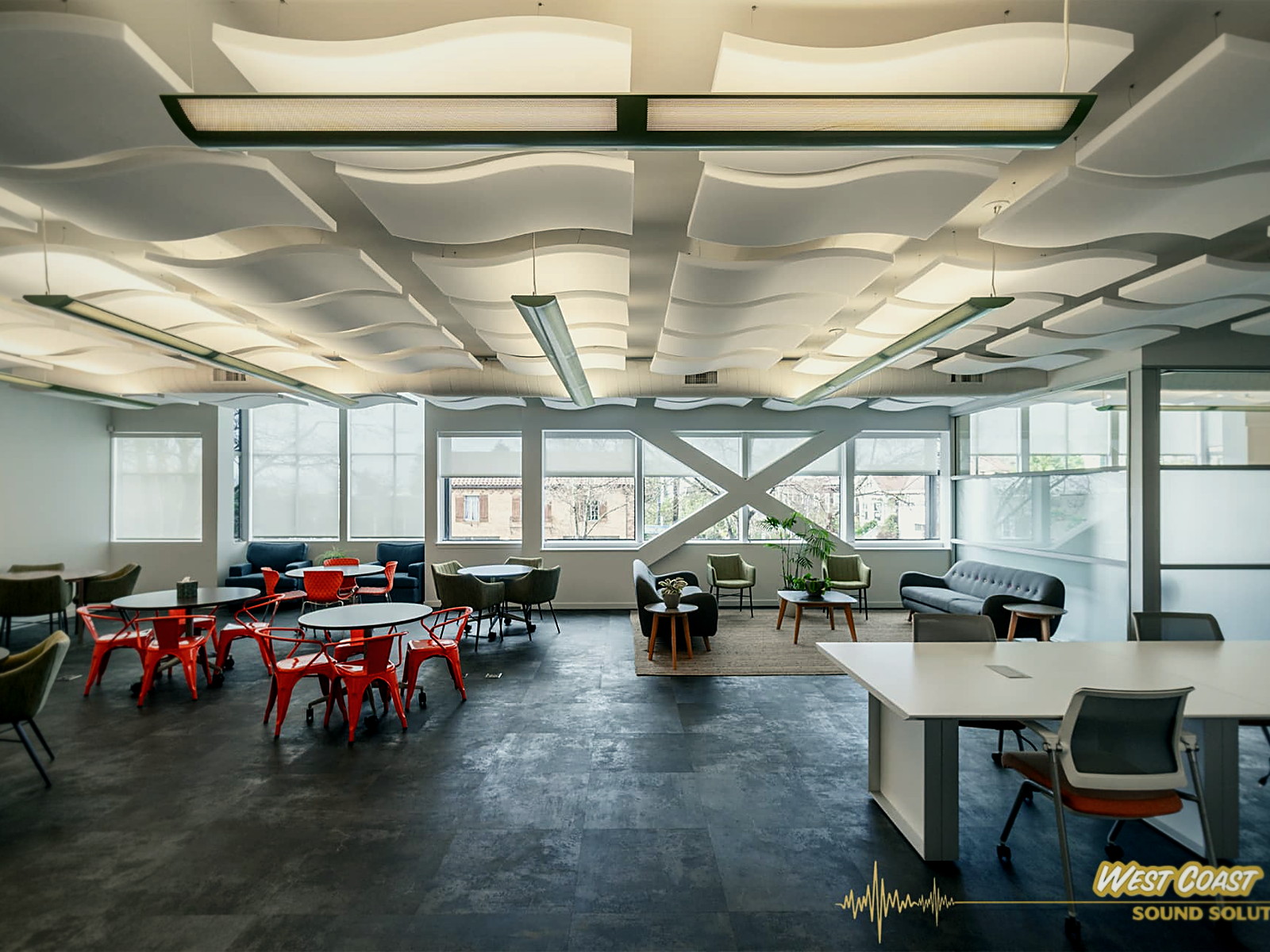 Open plan Berkeley office with a full field of wave-shaped white acoustic ceiling clouds over cafe tables and workstations