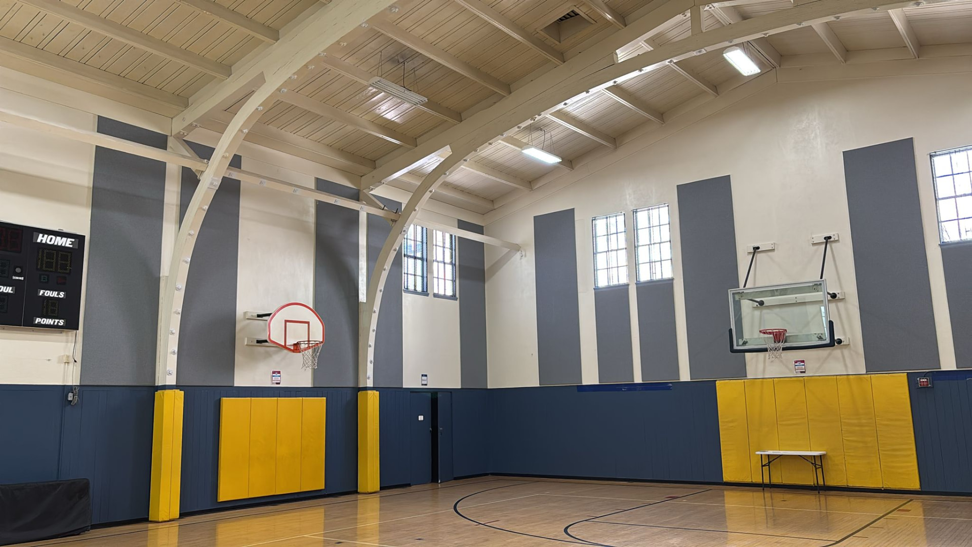 YMCA Buchanan gym after acoustic treatment with custom gray fabric track panels on the upper walls