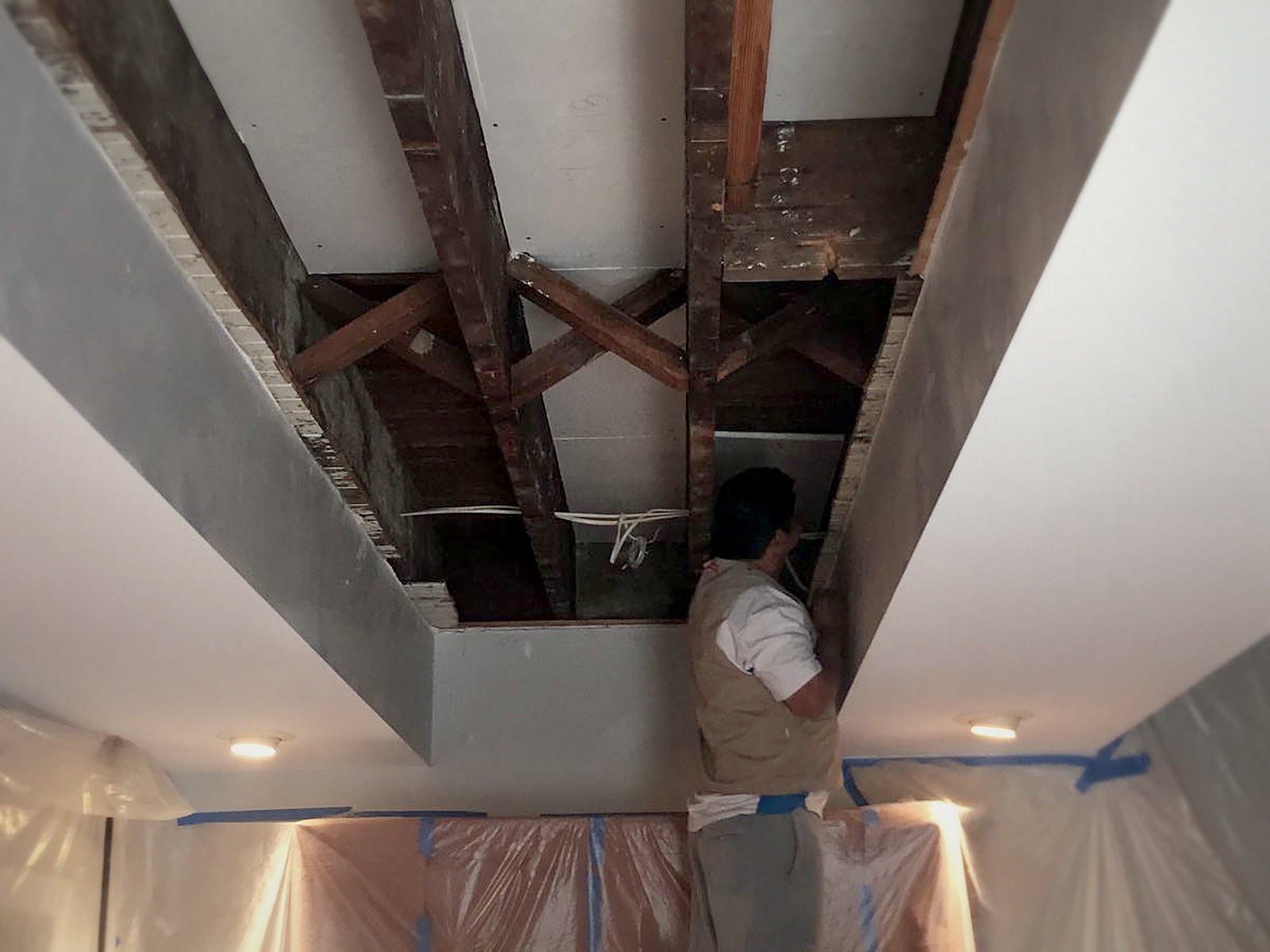 Installer finishing the last ceiling bay of a decoupled drywall assembly in a Melrose home