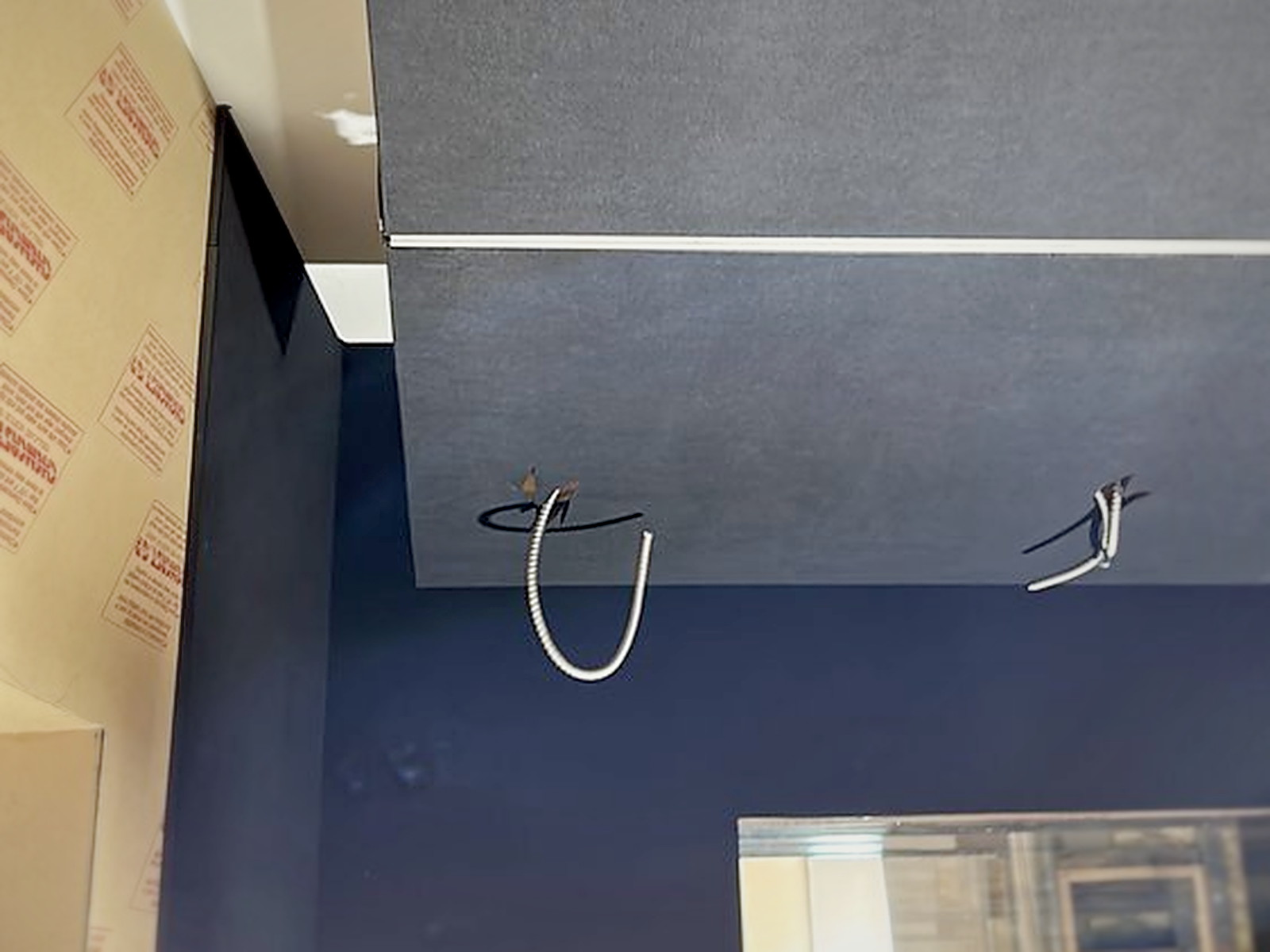 Recording studio ceiling rebuild with dark acoustic ceiling panels and conduit drops for lighting and monitors