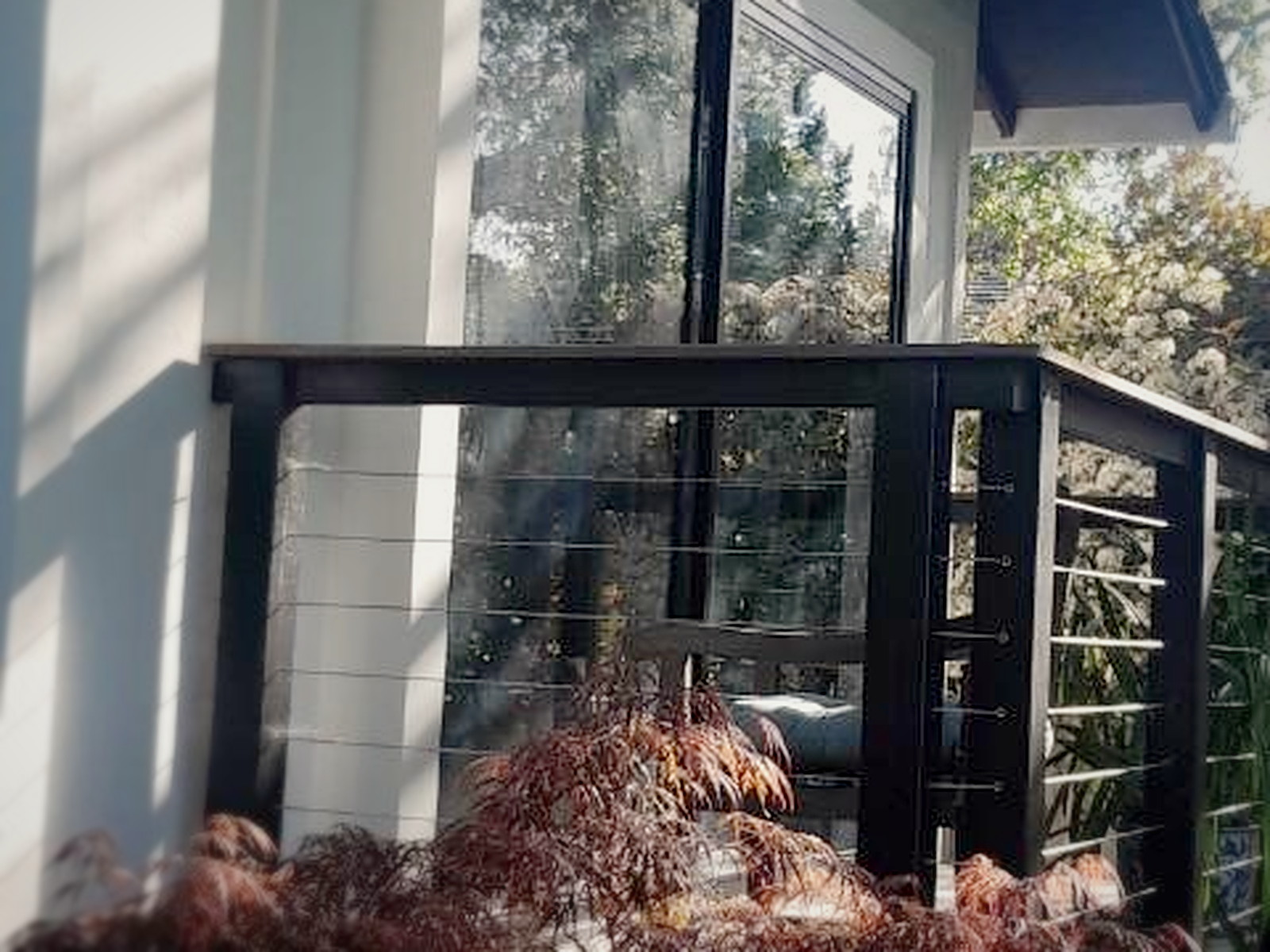 Finished secondary soundproof sliding glass door in a black frame on the patio side of an Orinda home